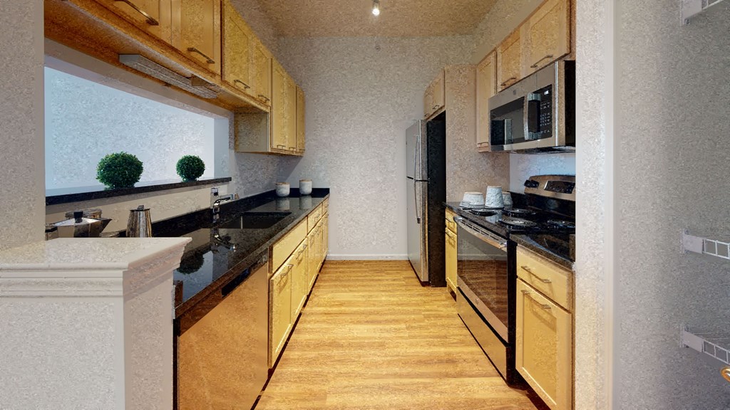 a kitchen with wooden cabinets and black counter tops