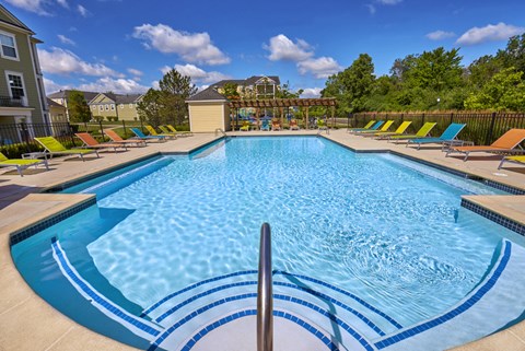 our resort style pool is filled with lounge chairs and a variety of blue and white
