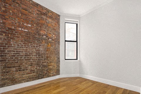 an empty room with a brick wall and a window