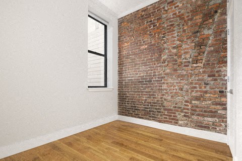 an exposed brick wall in an empty room with a window