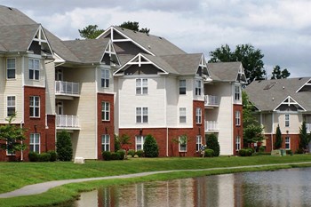 Walking path around stocked fishing lake outdoor elevation of Harbour Breeze apartment home building