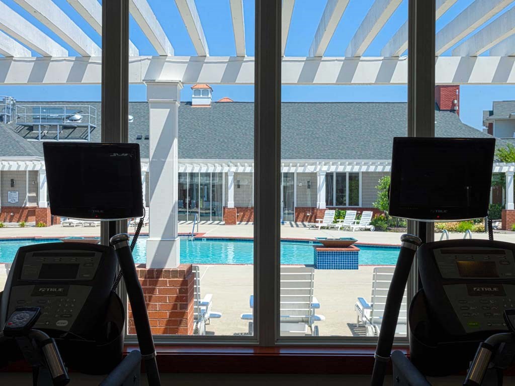 fitness center has a view of the pool at 1200 Acqua Luxury Apartments in Petersburg