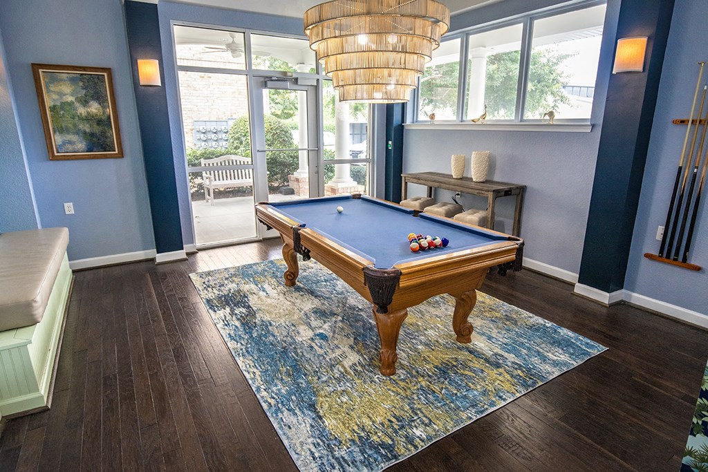 A pool table in a room with a view outside.