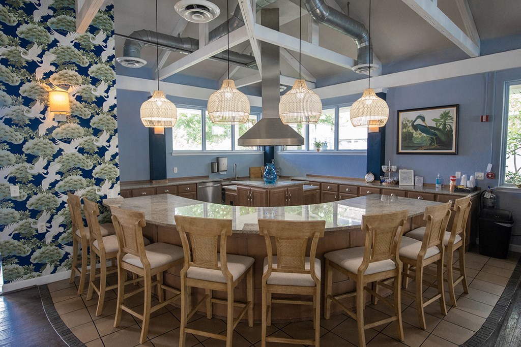 A kitchen with a large island and chairs.