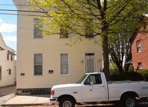 a white truck parked in front of a white house