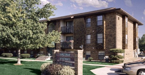 A brick apartment building with a sign that says "Hamilton Apartments".