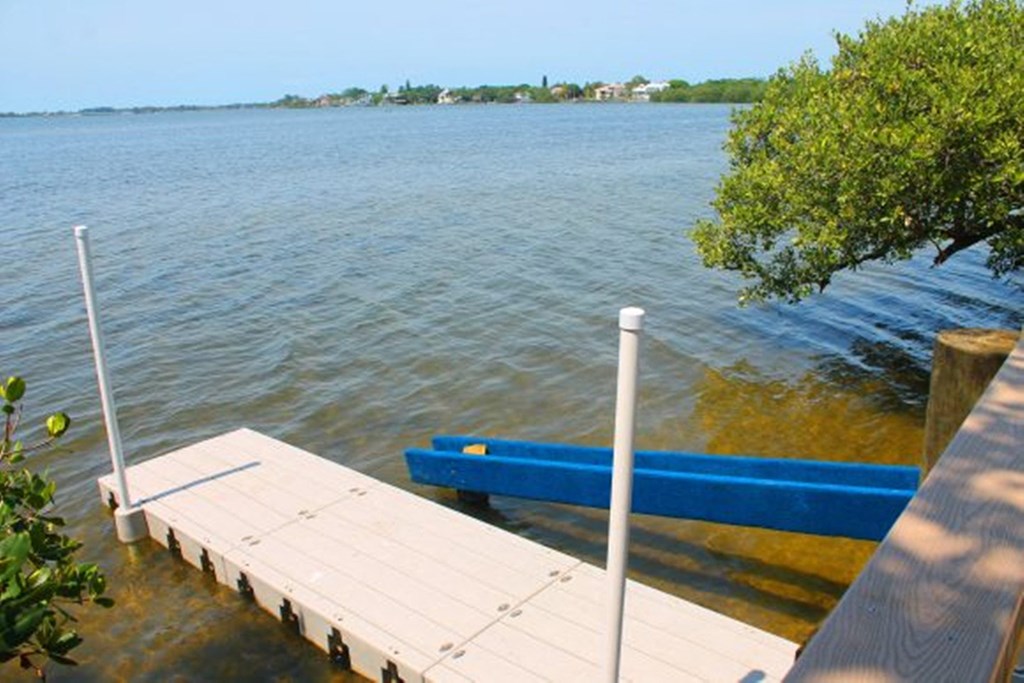 a dock with a blue bench on the water