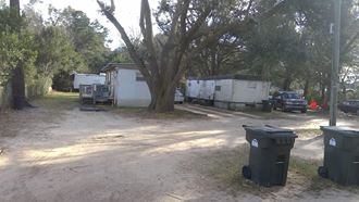 a group of trailers are parked under a tree