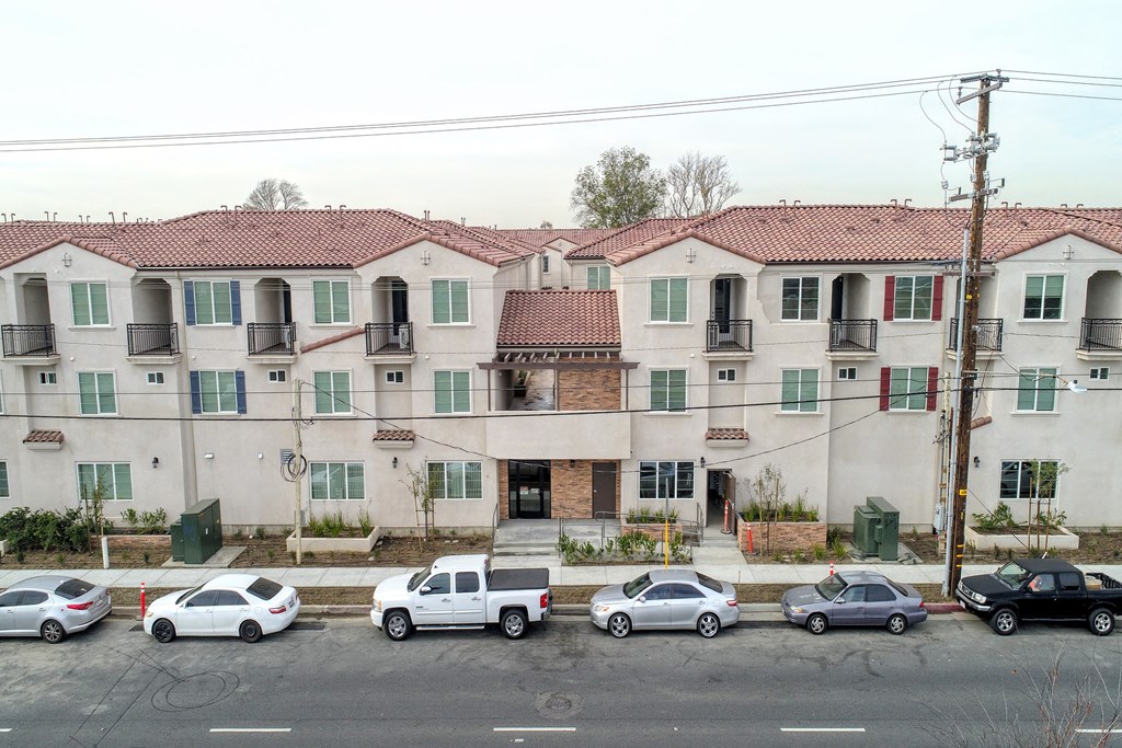 an apartment building on a city street with cars parked in front