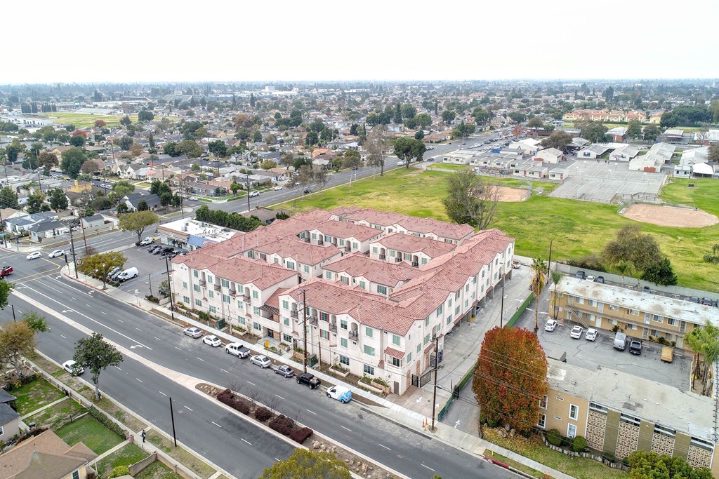 an aerial view of a building with a red roof on a city street