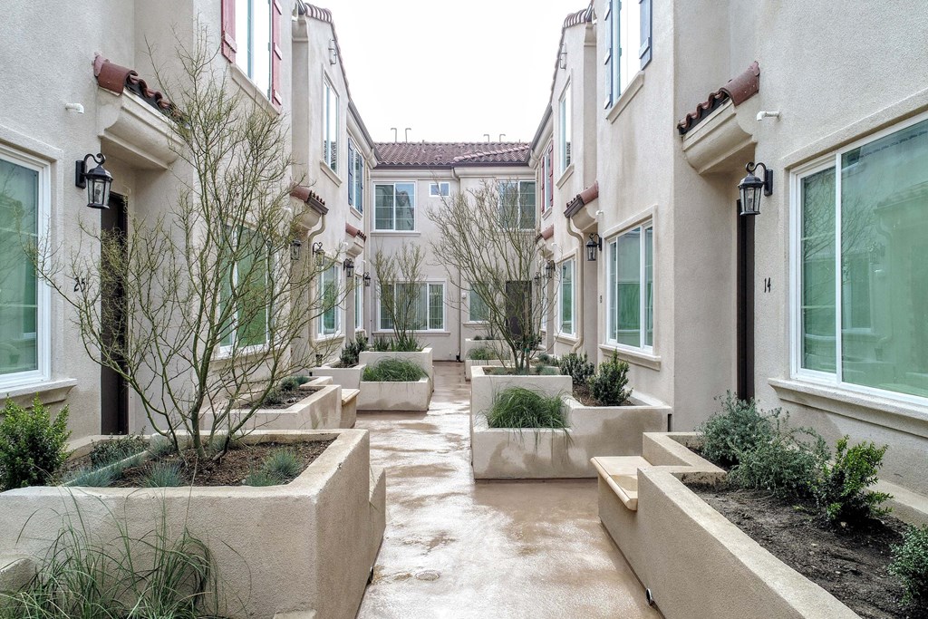 the courtyard of an apartment building with large concrete planters