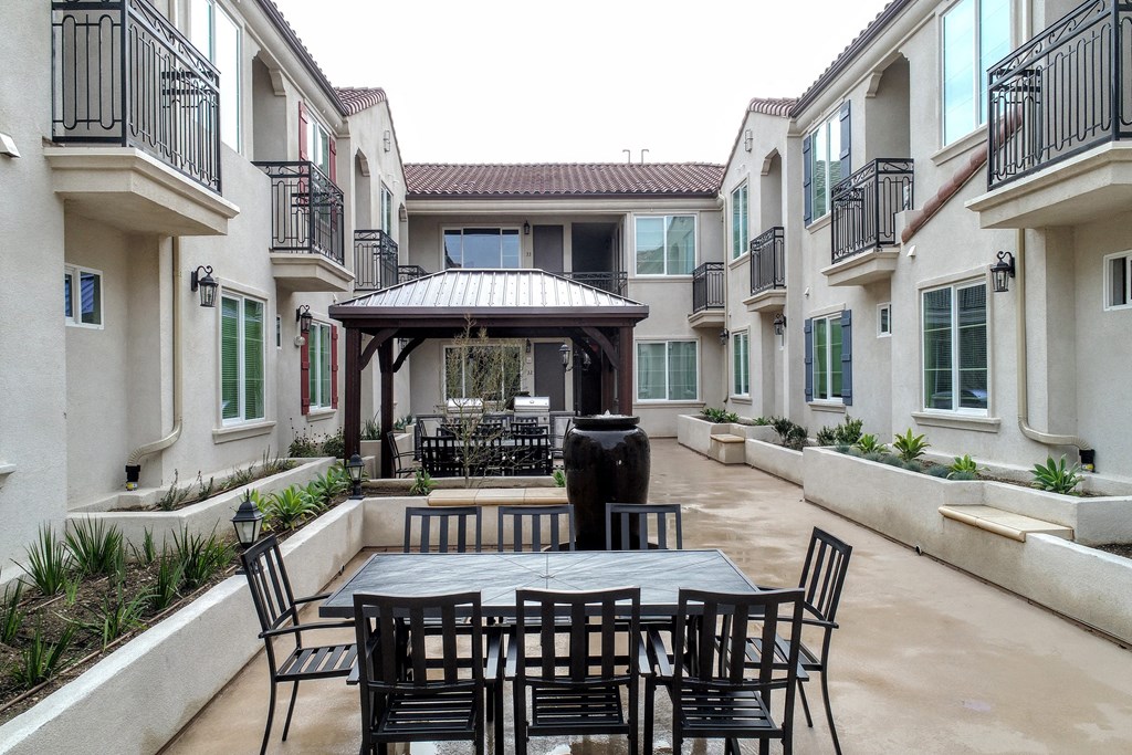 a patio with a table and chairs and a fountain