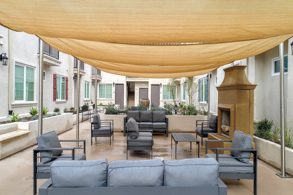 a large patio with couches and chairs and a fireplace