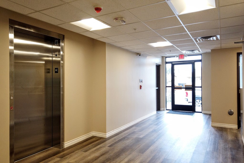 a lobby with an elevator and a glass door