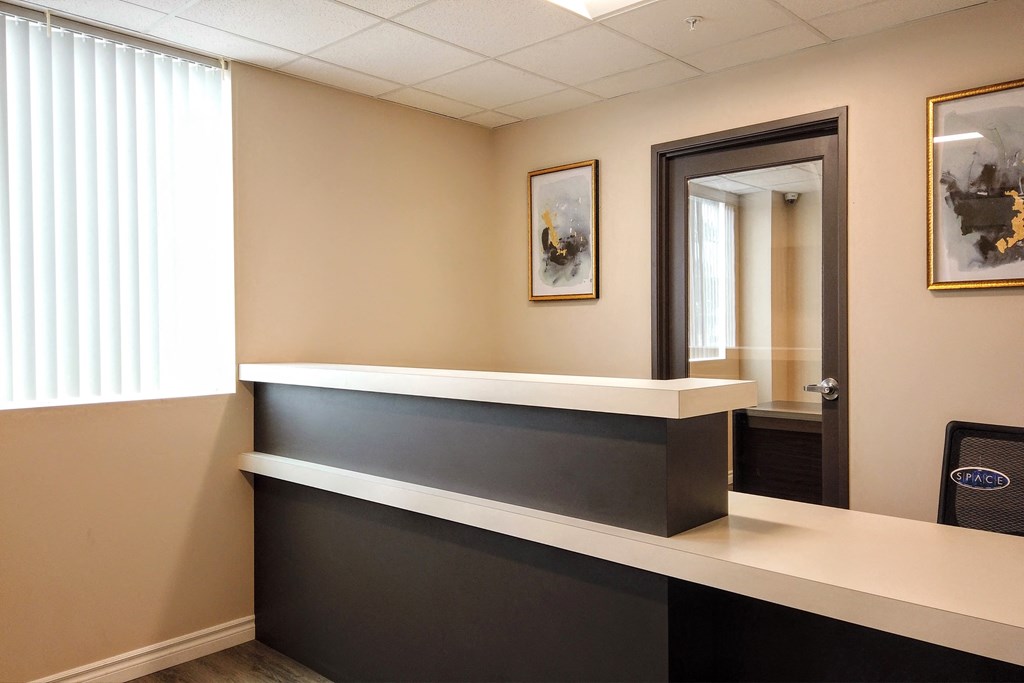 a reception desk in a doctors office with a door to the exam room
