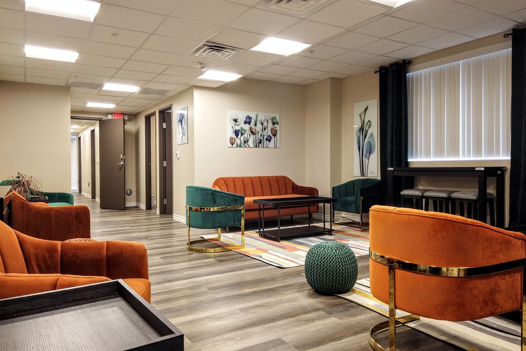 a waiting room with orange chairs and a piano