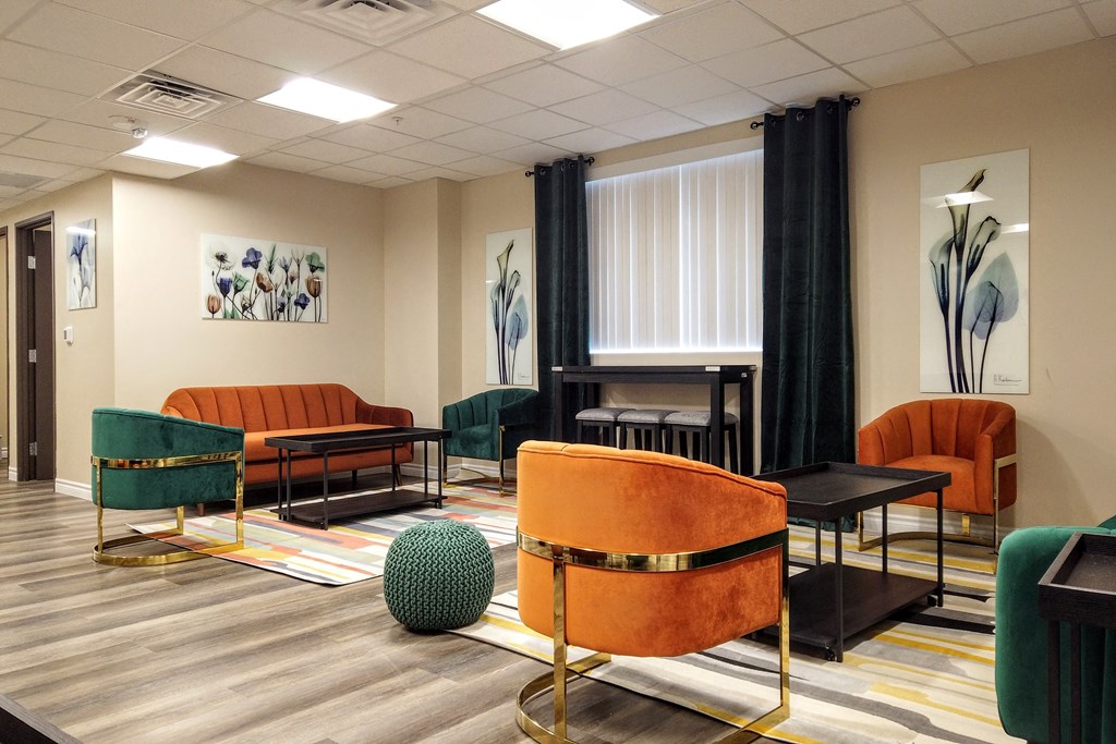a living room with chairs and tables and a piano