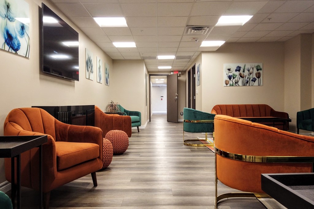 a lobby with couches and chairs and a tv