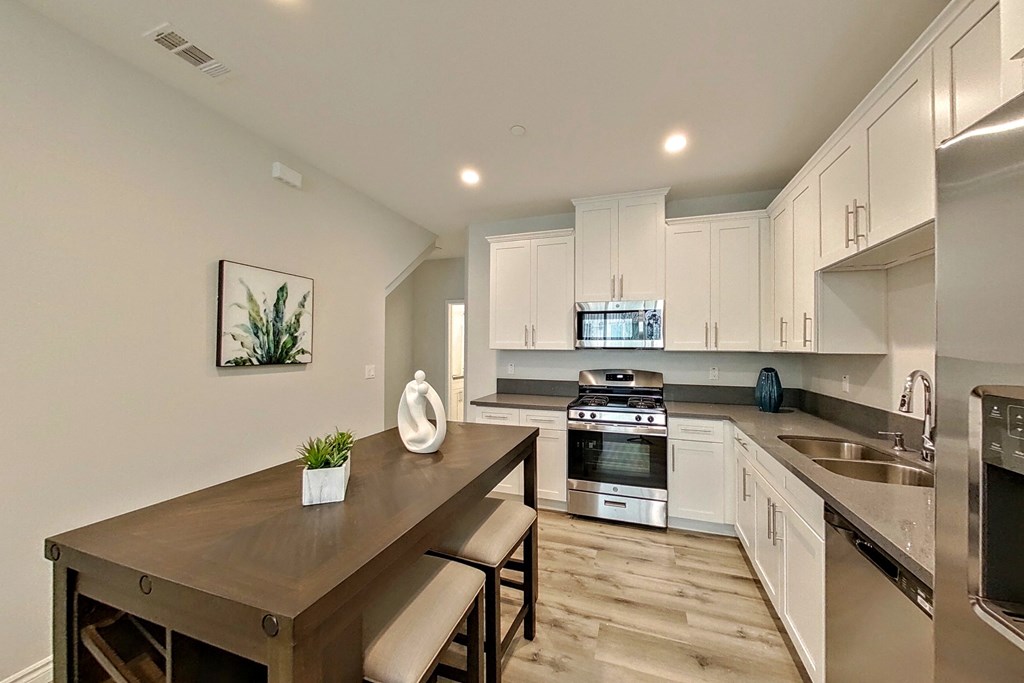 a kitchen with white cabinets and a wooden table