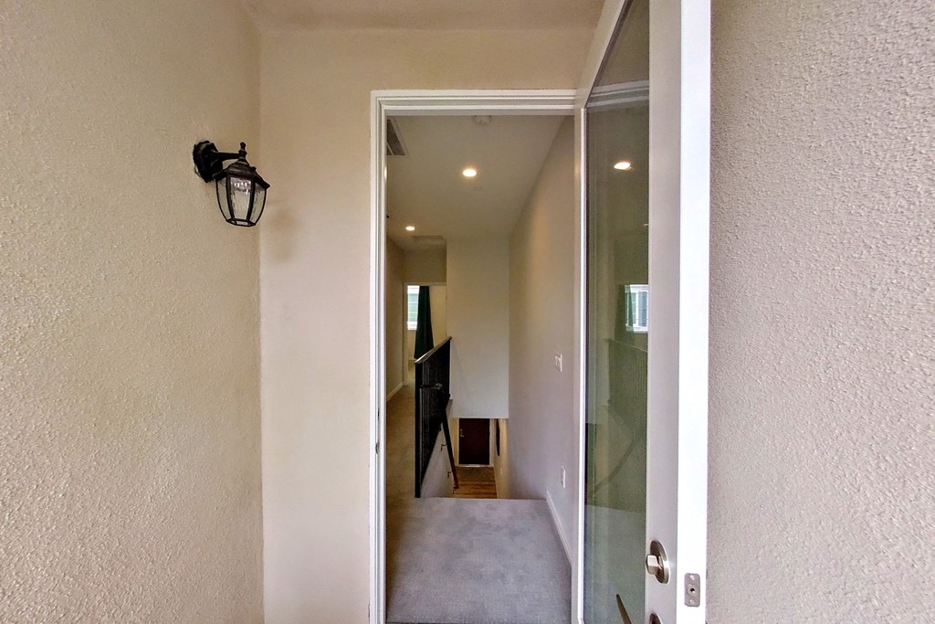 a view of the hallway from theoyer of a house with a large glass door