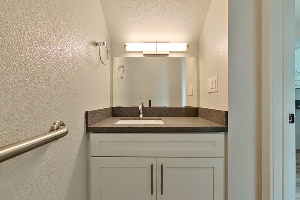 an empty bathroom with a sink and a mirror