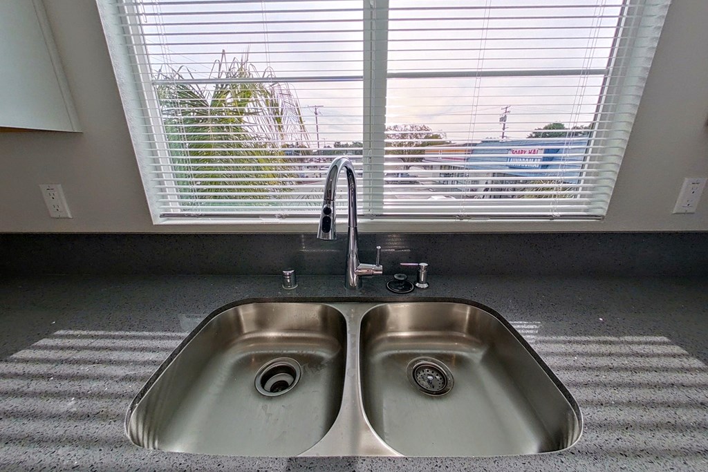 a kitchen sink in front of a window