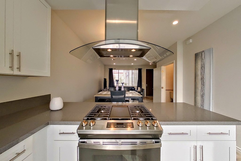 a large kitchen with white cabinets and stainless steel appliances