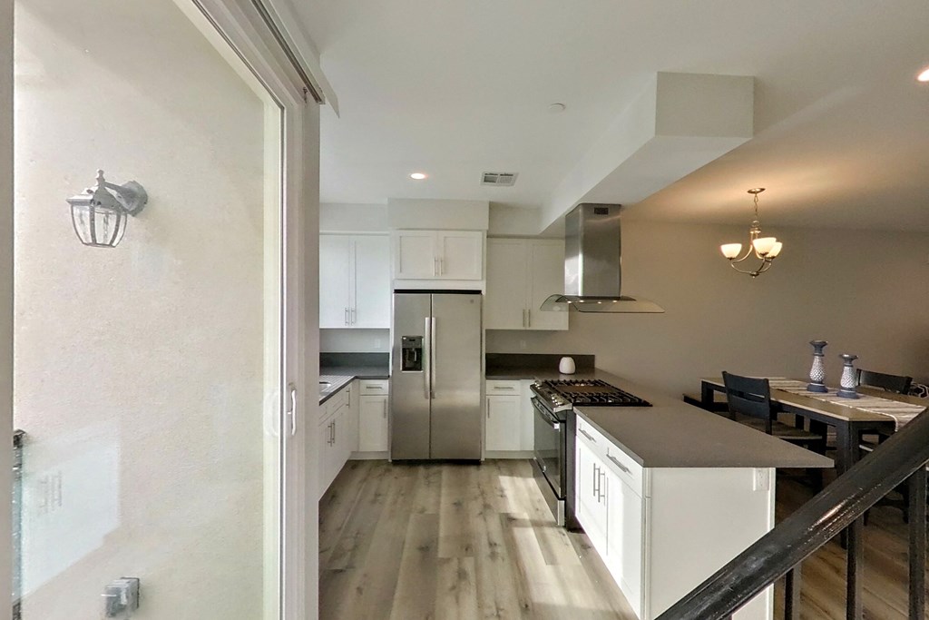 a renovated kitchen with white cabinets and stainless steel appliances