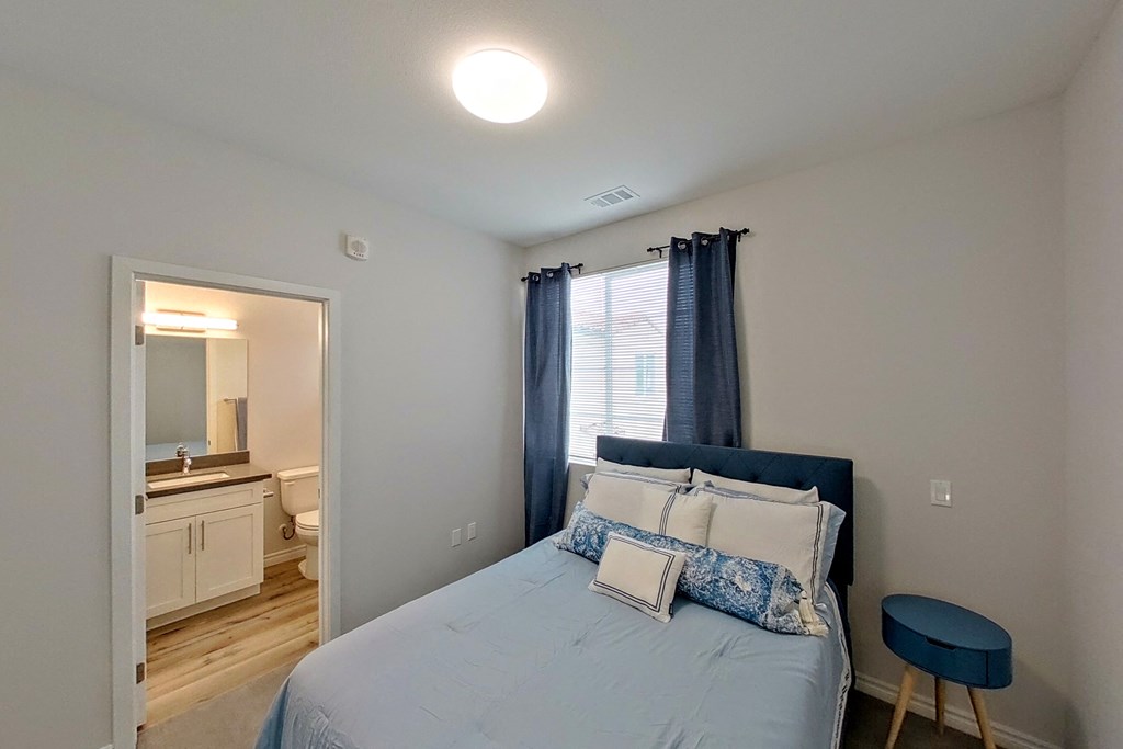 a bedroom with a bed and a door to a bathroom