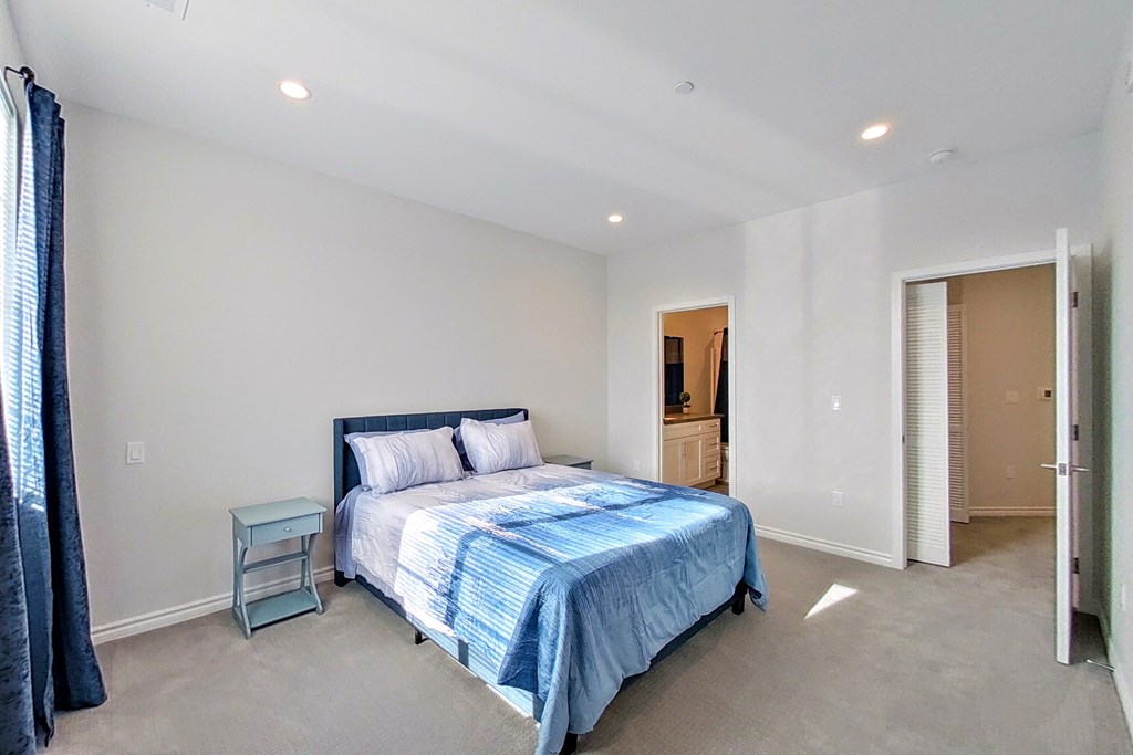 a bedroom with a bed and a door to a bathroom