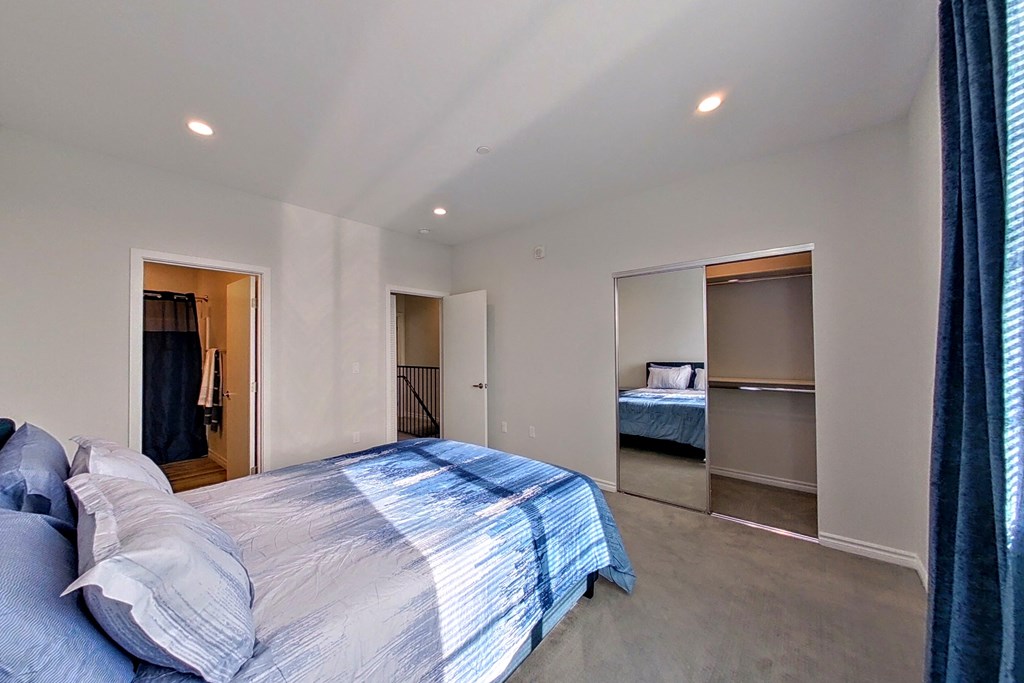 a master bedroom with a large bed and a closet