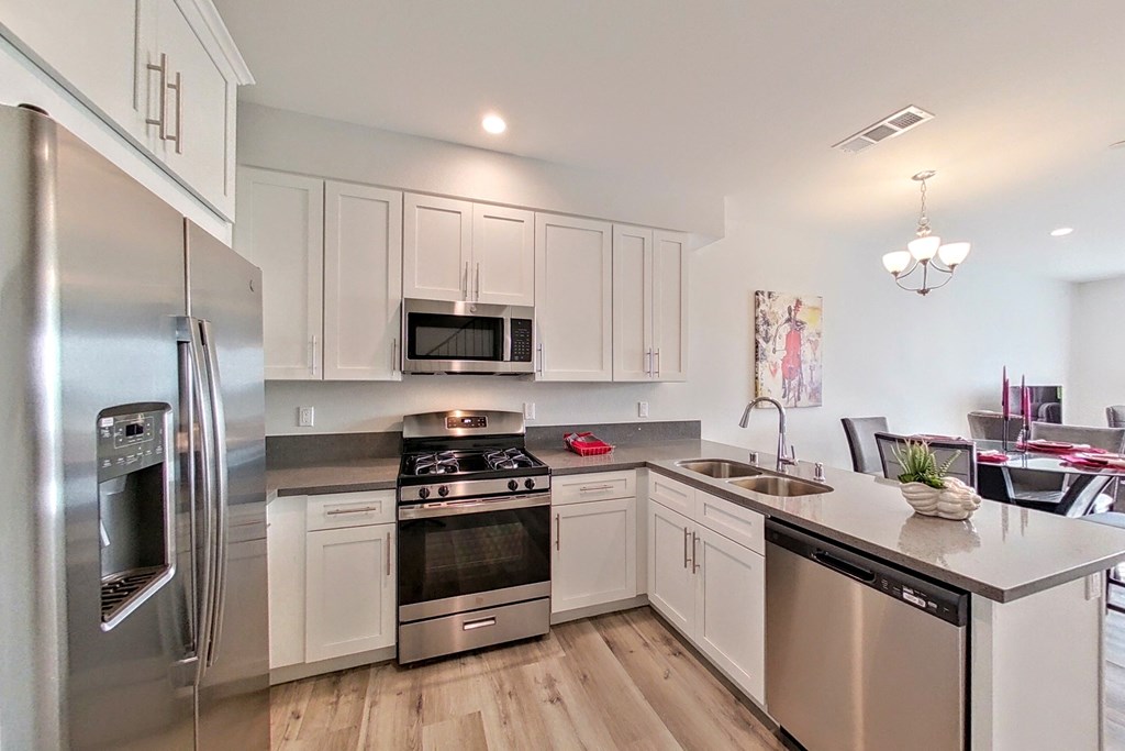 a kitchen with stainless steel appliances and white cabinets