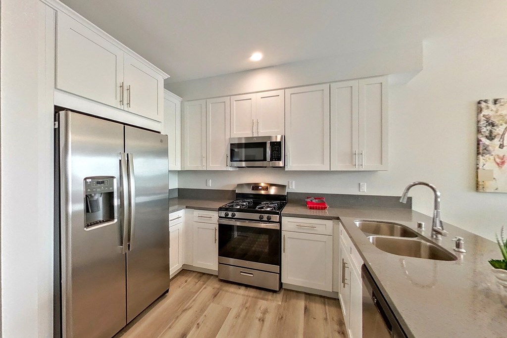 a modern kitchen with stainless steel appliances and white cabinets
