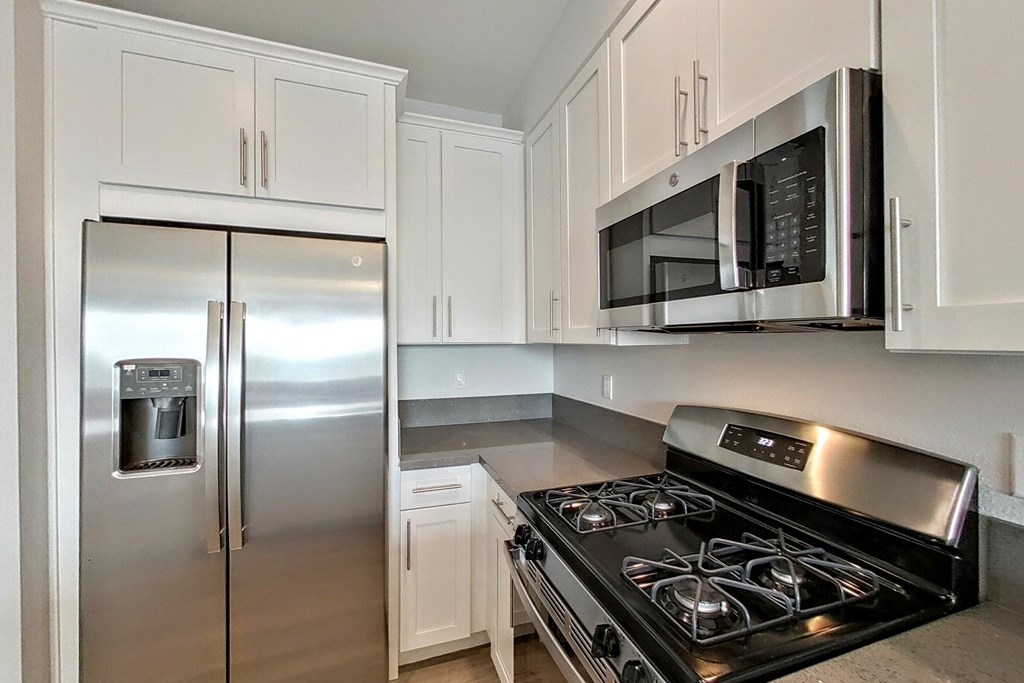 a kitchen with stainless steel appliances and white cabinets