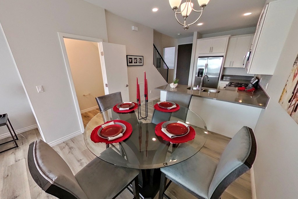 a dining room with a glass table and chairs and a kitchen