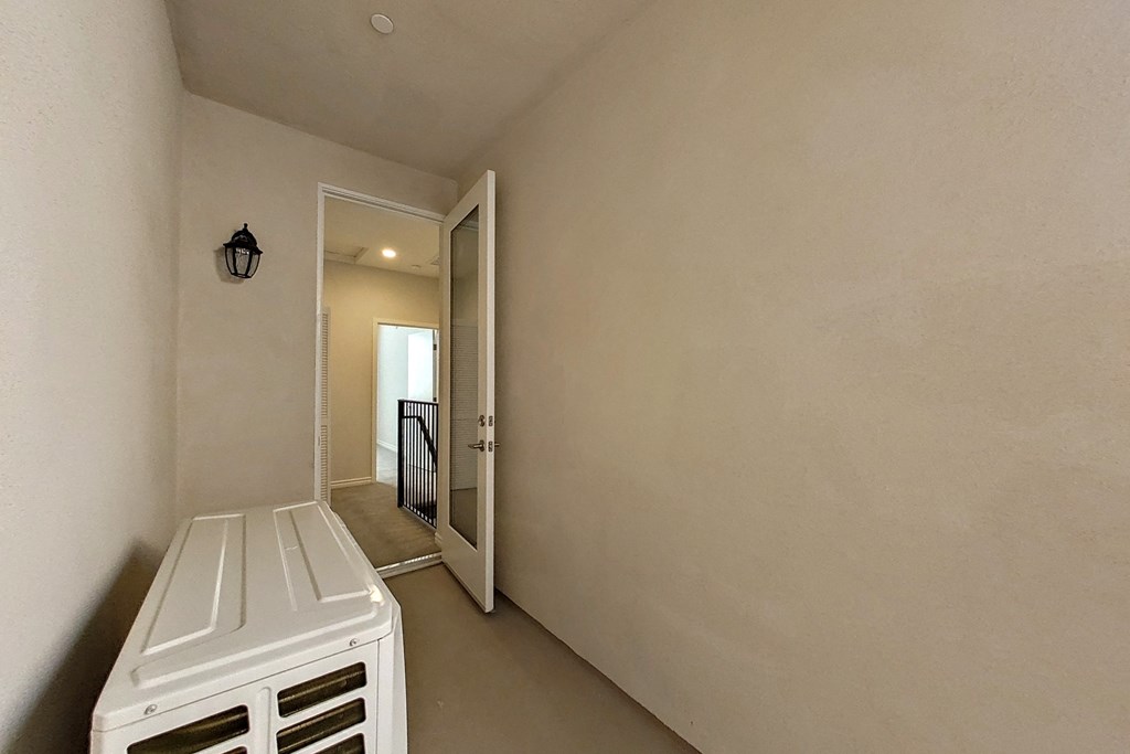 the laundry room has a washer and dryer and a door to the hallway