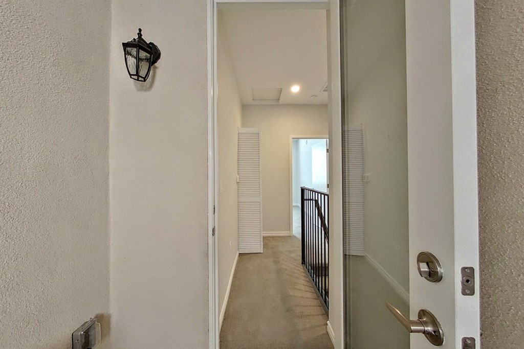 the view of the hallway from the front door of a house