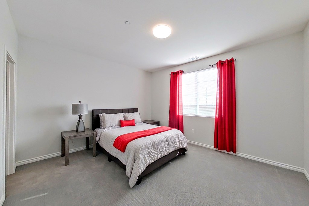 a bedroom with a bed and red curtains