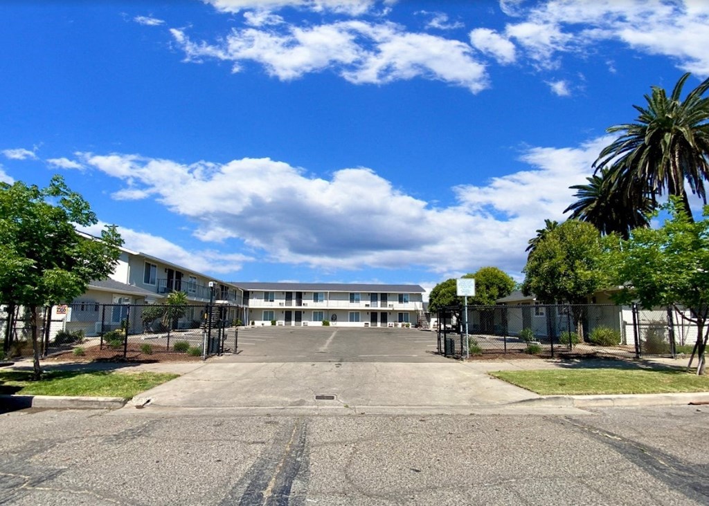 a large empty parking lot in front of an apartment building