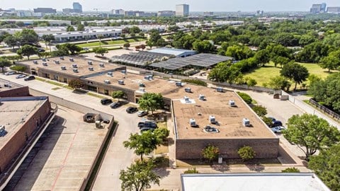 an aerial view of a parking lot with cars and buildings