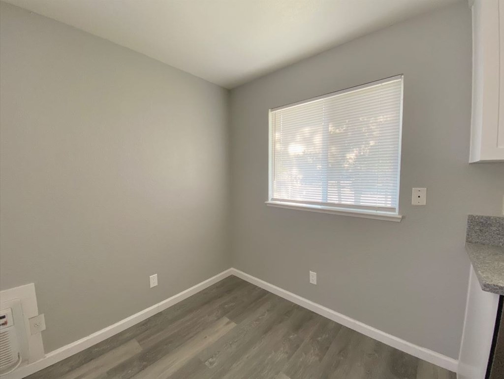 a living room with a window and wooden floors
