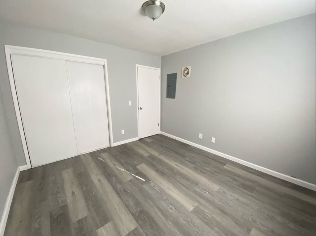 a room with hardwood floors and grey walls and white doors