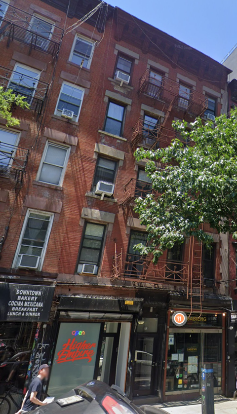 a man walking down a street in front of a building