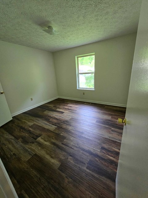 a living room with a hard wood floor and a window