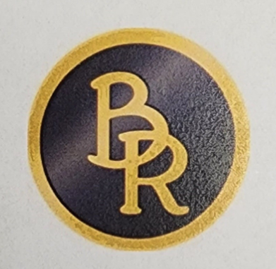 a gold and black badge with a r logo on it