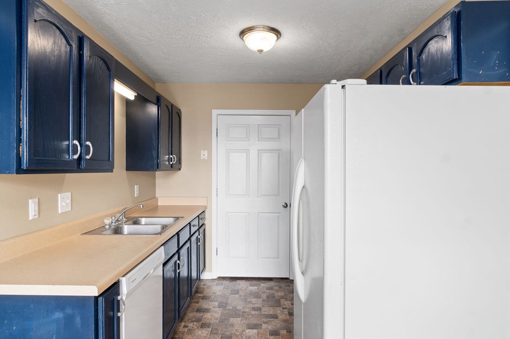 a kitchen with a white refrigerator and a sink