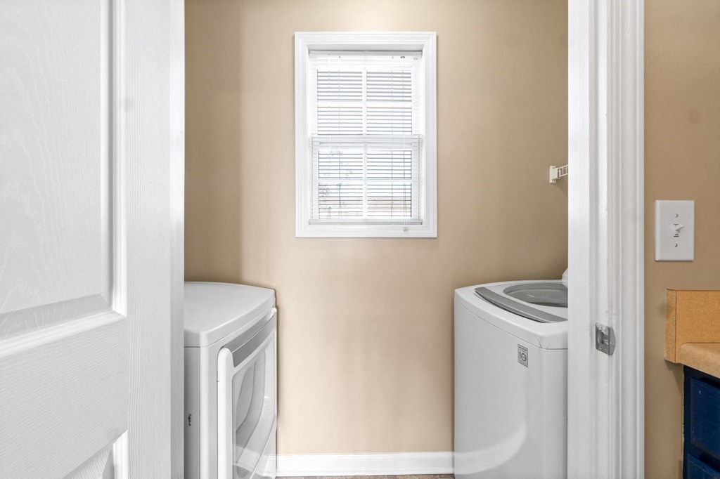 a small laundry room with a washer and dryer and a window