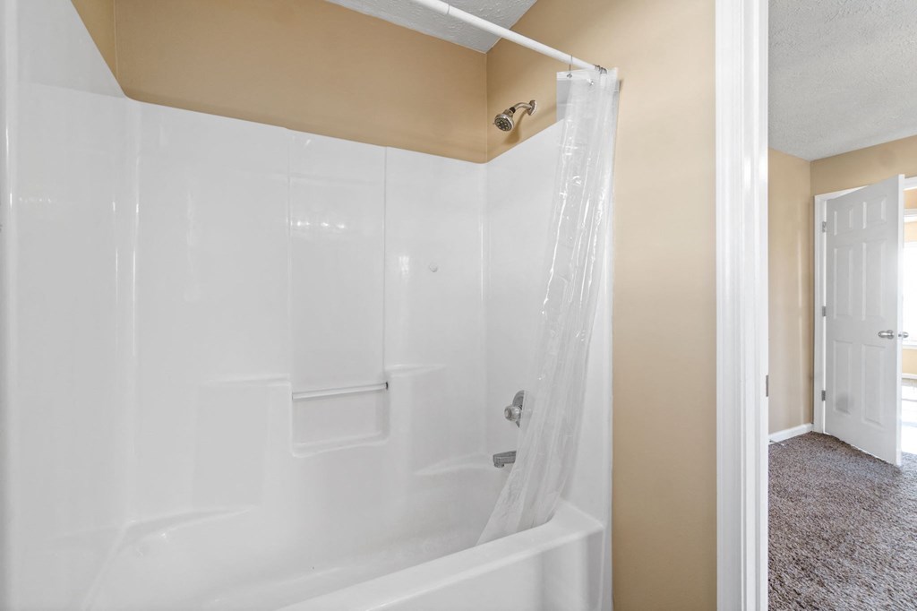a white bathroom with a shower and a door