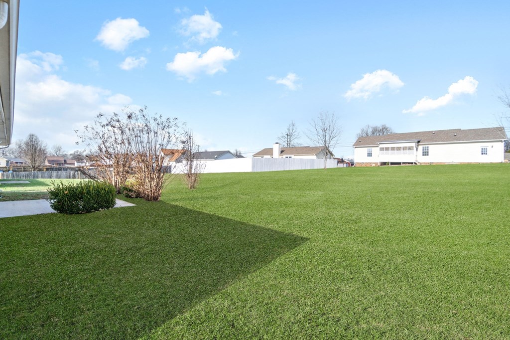 a large lawn with a house in the background