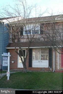 a red brick house with a tree in front of it